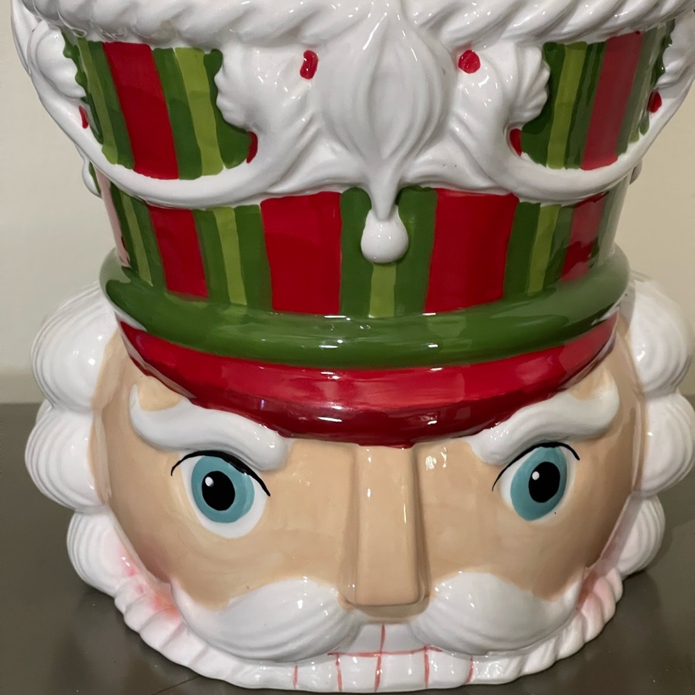 Nutcracker cookie jar decorated in Christmas red, green and white.